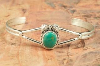 Genuine Royston Turquoise set in Sterling Silver Bracelet. The Royston Turquoise Mine was originally known as the Royal Blue Mine. It produces Turquoise that has a mixture of blues and greens in the same formation. The Royston Turquoise Mine is located in Nye County, Nevada. Created by Navajo Artist Lucy Valencia. Signed L. J. by the artist.
